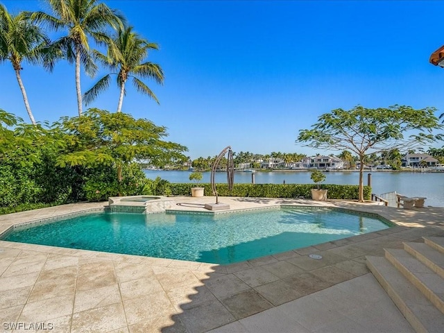 view of pool with an in ground hot tub, a patio, and a water view