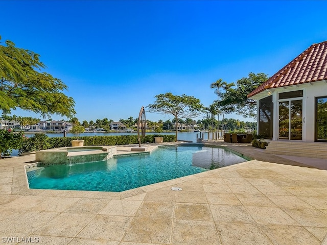 view of pool featuring an in ground hot tub, a patio, and a water view