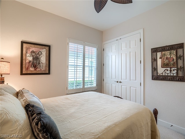 bedroom with ceiling fan, carpet, and a closet