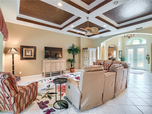 living room with french doors, light tile floors, crown molding, coffered ceiling, and ceiling fan with notable chandelier