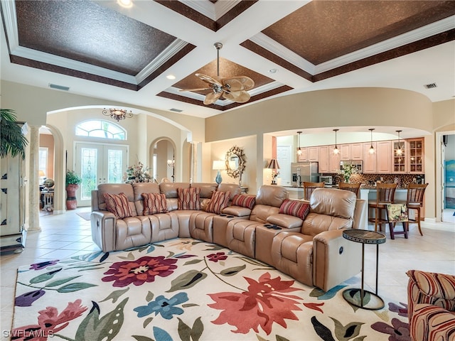 living room featuring coffered ceiling, ceiling fan, light tile floors, crown molding, and french doors