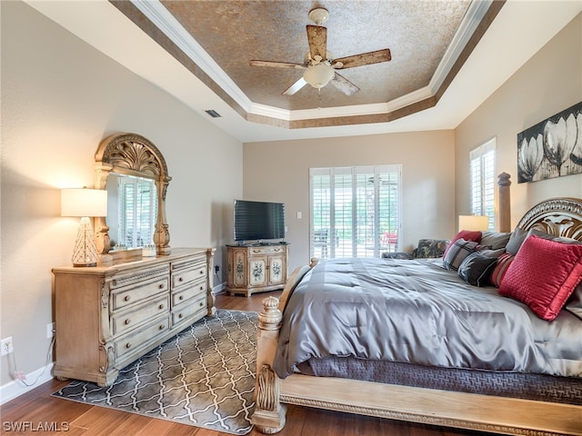 bedroom featuring a raised ceiling, ceiling fan, and dark hardwood / wood-style floors