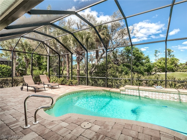 view of pool featuring glass enclosure and a patio area