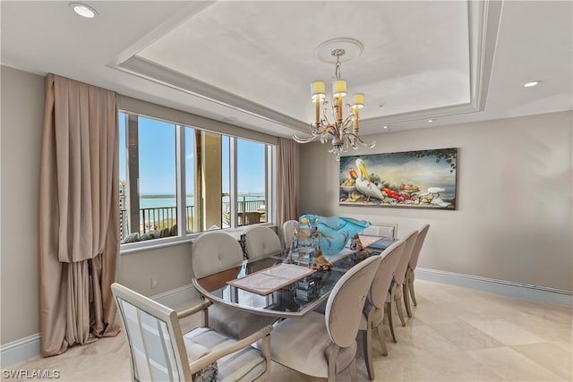 dining space with a chandelier, a water view, a raised ceiling, and light tile floors