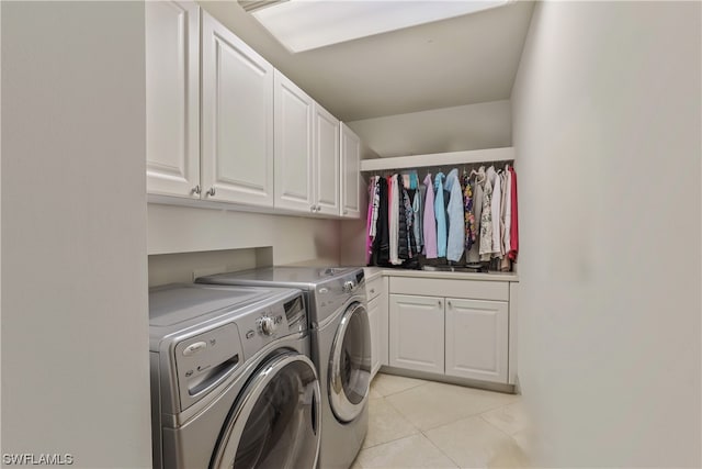 laundry room with cabinets, light tile floors, and washing machine and clothes dryer