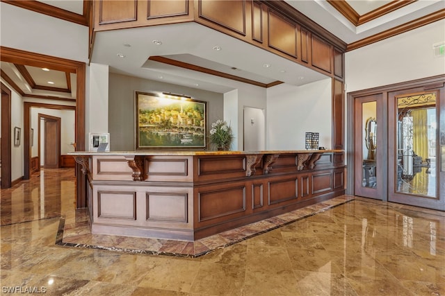 foyer with crown molding, a tray ceiling, and tile flooring