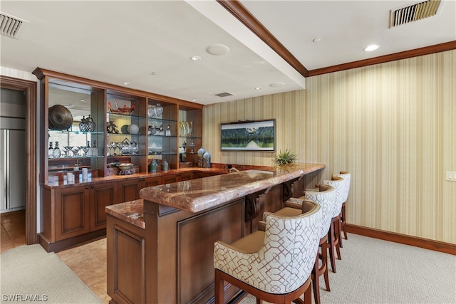 bar featuring dark stone counters and light tile floors