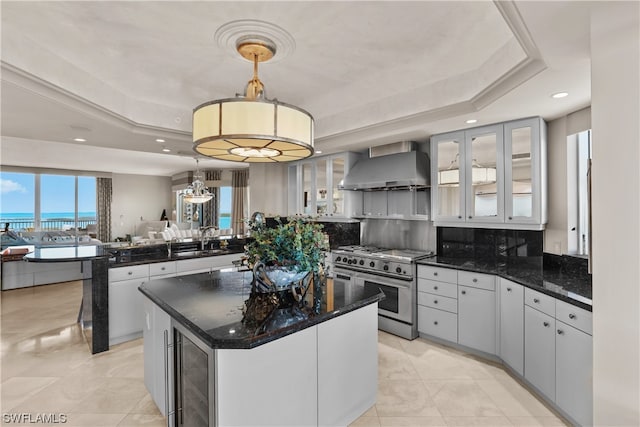 kitchen with a center island, double oven range, decorative light fixtures, wine cooler, and wall chimney exhaust hood