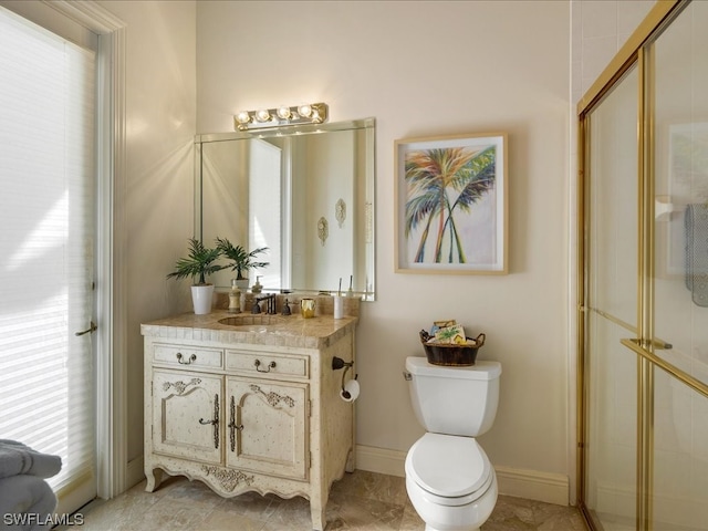 bathroom with vanity, toilet, and a shower with door