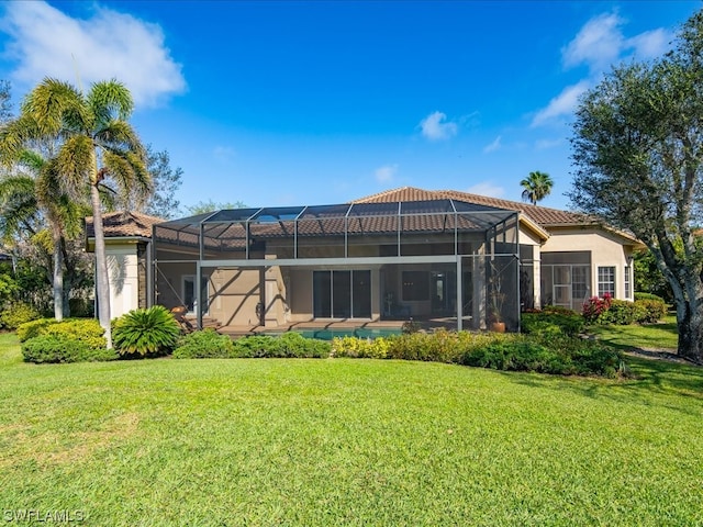 rear view of property featuring glass enclosure and a yard