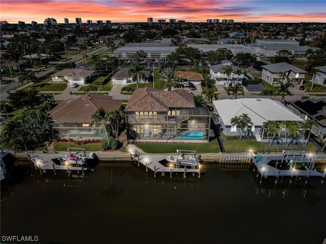 aerial view at dusk featuring a water view