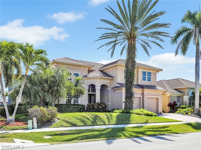 mediterranean / spanish house with a front lawn and a garage