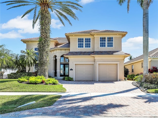 mediterranean / spanish-style house featuring a front yard and a garage