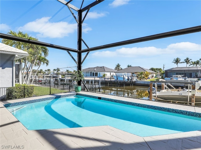 view of pool featuring glass enclosure, a dock, and a water view