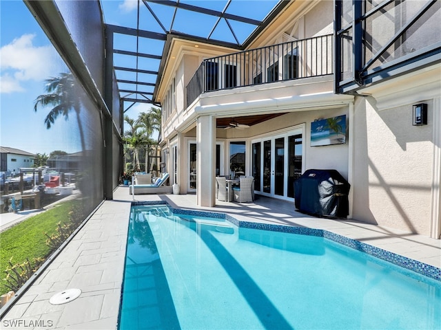 view of pool with a lanai, ceiling fan, a patio area, and french doors