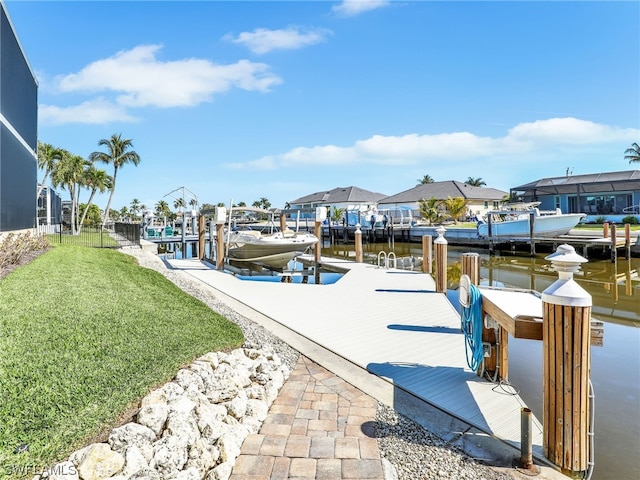 view of dock featuring a water view and a yard