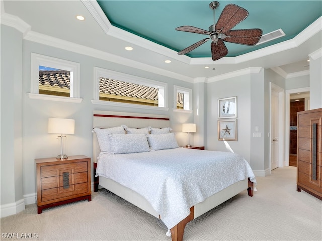 bedroom with crown molding, a tray ceiling, light carpet, and ceiling fan