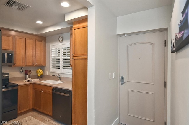 kitchen with light tile patterned floors, sink, and black appliances