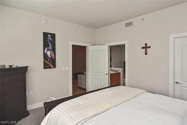 carpeted bedroom featuring ensuite bath