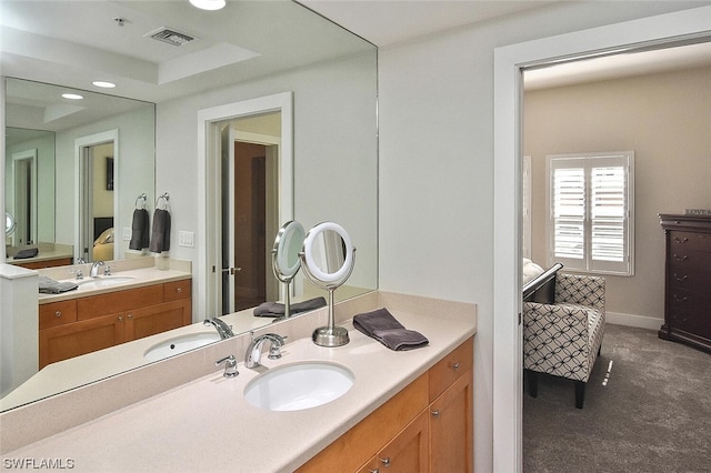 bathroom with vanity and a tray ceiling