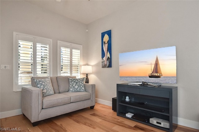 sitting room with light hardwood / wood-style floors and a water view