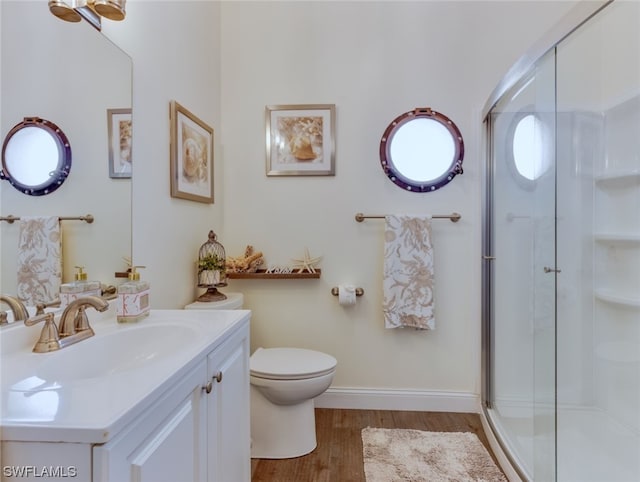 bathroom with toilet, a shower with door, hardwood / wood-style floors, and oversized vanity