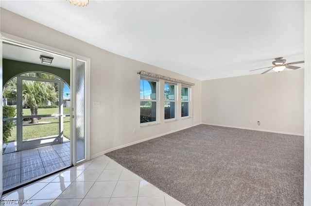 carpeted spare room featuring plenty of natural light and ceiling fan