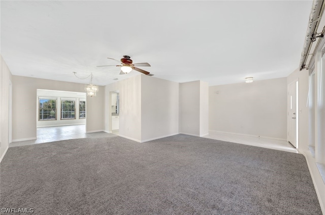 carpeted empty room featuring ceiling fan with notable chandelier