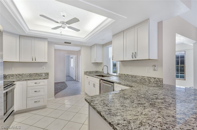 kitchen featuring white cabinets, a raised ceiling, and stainless steel appliances