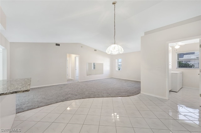 unfurnished room with washer / clothes dryer, vaulted ceiling, light tile floors, and ceiling fan with notable chandelier