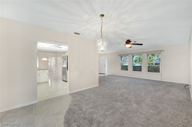 empty room with ceiling fan with notable chandelier and light colored carpet