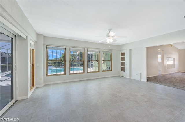 tiled empty room featuring ceiling fan