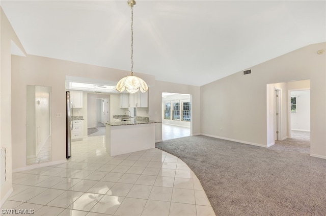 spare room with an inviting chandelier, light carpet, lofted ceiling, and sink