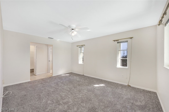 spare room with light colored carpet and ceiling fan