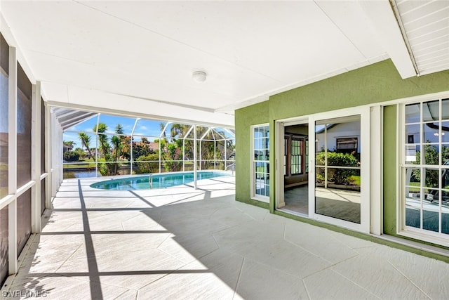 view of swimming pool with glass enclosure and a patio