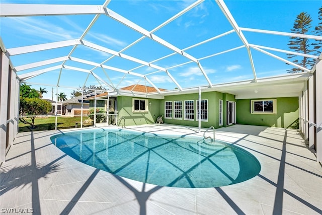 view of pool with a patio and glass enclosure