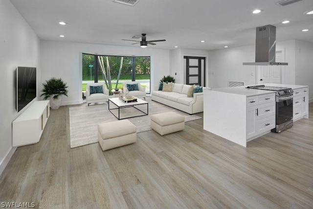 living room with light hardwood / wood-style floors and ceiling fan