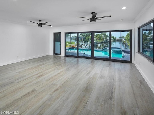 spare room with ceiling fan, a wealth of natural light, and light hardwood / wood-style flooring