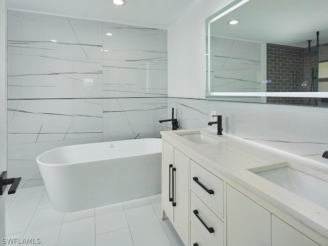 bathroom with tile patterned flooring, vanity, tile walls, and plus walk in shower