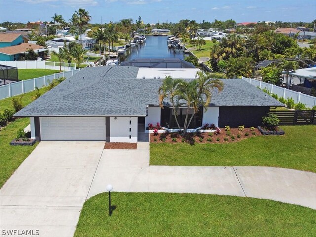 view of front of property featuring a garage, a water view, and a front yard