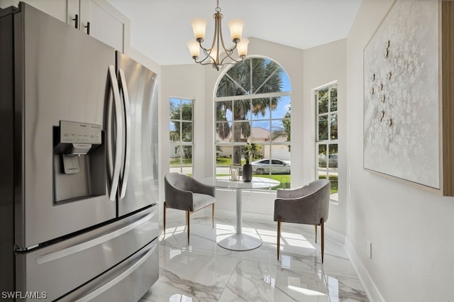 kitchen with a healthy amount of sunlight, a notable chandelier, and stainless steel refrigerator with ice dispenser