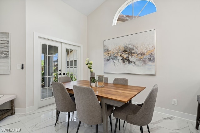 dining area with high vaulted ceiling and french doors