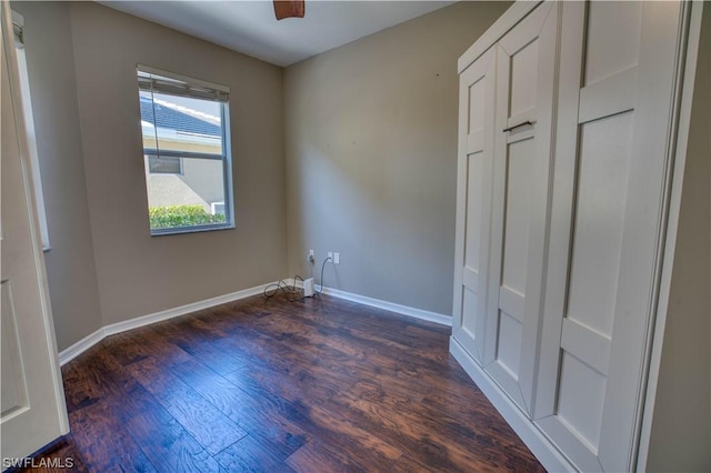 unfurnished bedroom with dark wood-type flooring and ceiling fan