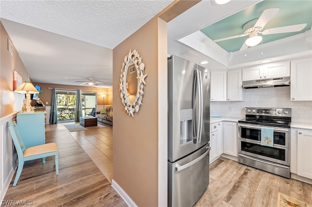 kitchen with light hardwood / wood-style floors, stainless steel appliances, ceiling fan, and white cabinetry