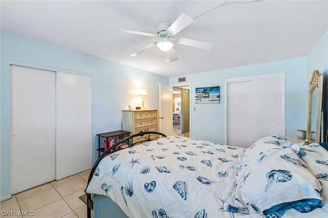 bedroom with light tile floors, a closet, and ceiling fan