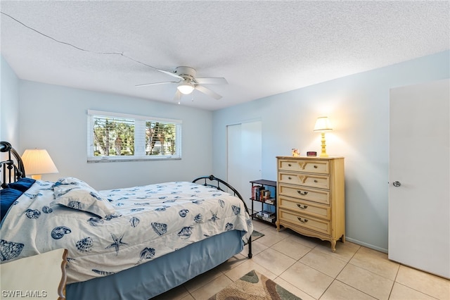 tiled bedroom with a textured ceiling and ceiling fan