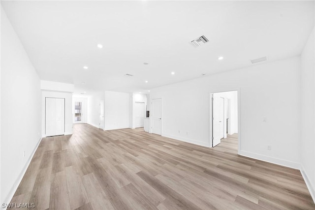 unfurnished living room featuring recessed lighting, visible vents, light wood-style flooring, and baseboards