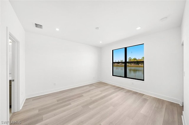 spare room featuring visible vents, recessed lighting, light wood-type flooring, and baseboards