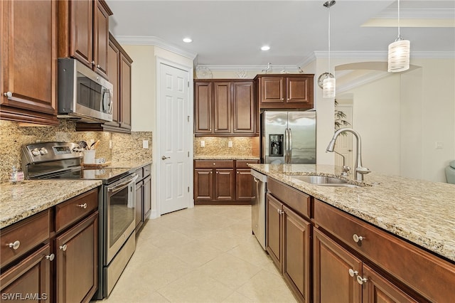 kitchen with stainless steel appliances, decorative light fixtures, light stone countertops, and sink