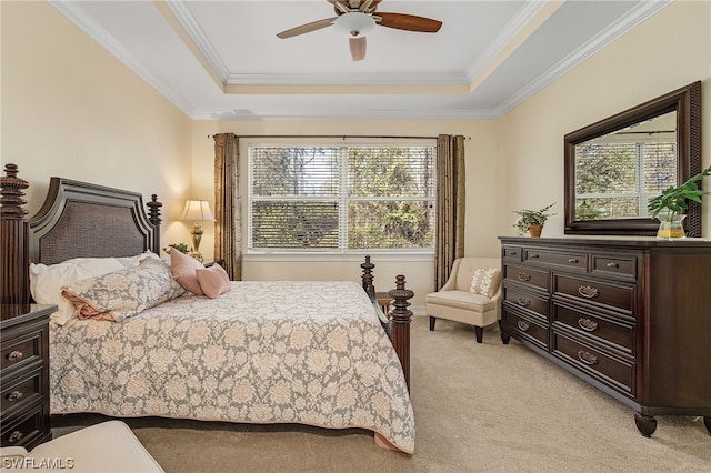 bedroom featuring light carpet, a tray ceiling, and crown molding